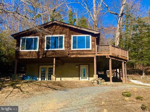 back of house with french doors, a deck, and stucco siding