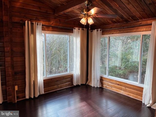 interior space with beam ceiling, wooden ceiling, and a ceiling fan