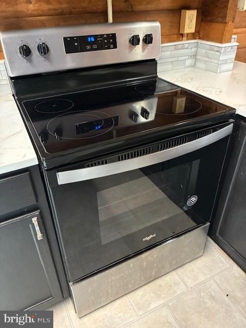 details with decorative backsplash and stainless steel range with electric stovetop