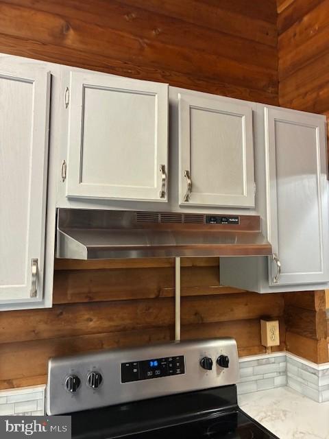 room details featuring under cabinet range hood, electric range, light countertops, and white cabinetry