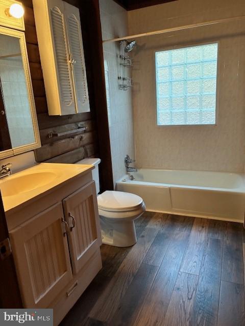bathroom with hardwood / wood-style floors, shower / tub combination, toilet, and vanity