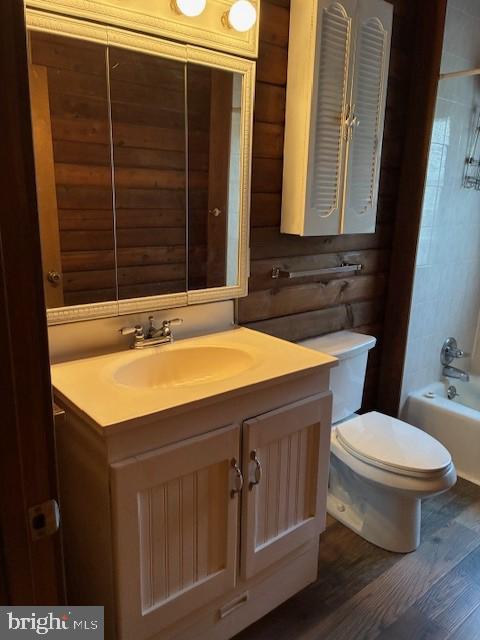 full bathroom with vanity, bathing tub / shower combination, toilet, and wood finished floors