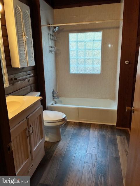 bathroom featuring wood-type flooring, toilet, shower / washtub combination, and vanity