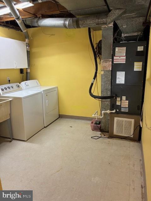 clothes washing area with tile patterned floors, cabinet space, baseboards, and washer and clothes dryer