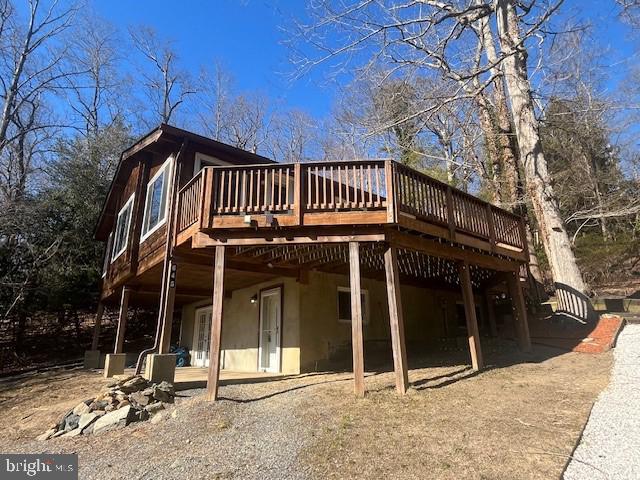 back of house featuring stucco siding and a deck