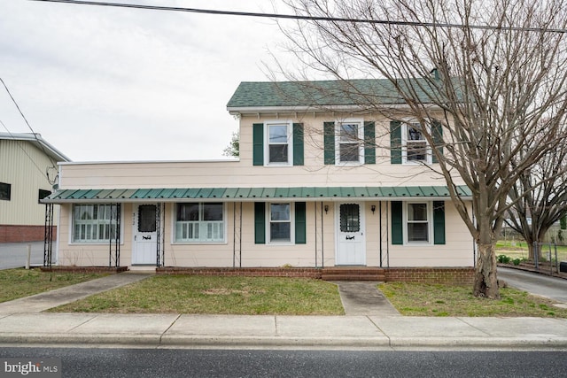 view of front of house featuring a porch, metal roof, and a front yard