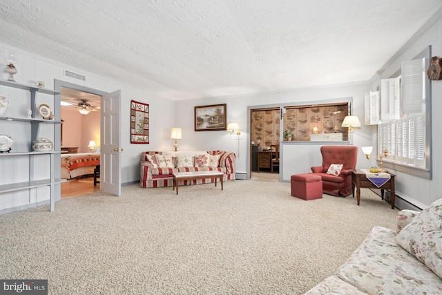 carpeted living area featuring ceiling fan, a textured ceiling, visible vents, a baseboard heating unit, and ornamental molding