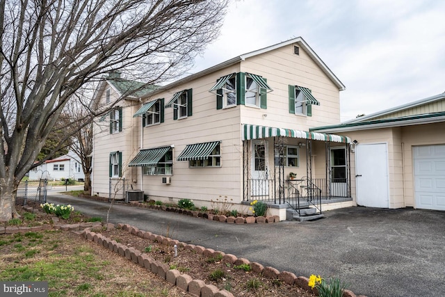 view of front of property with central AC unit and aphalt driveway