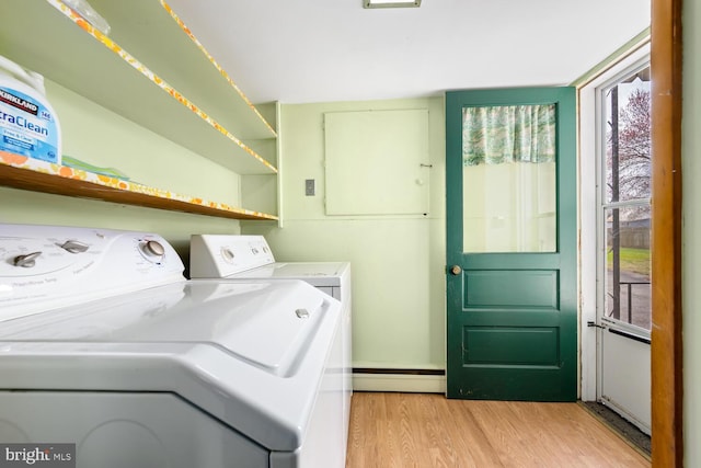 washroom with light wood-style floors, laundry area, baseboard heating, and washer and dryer