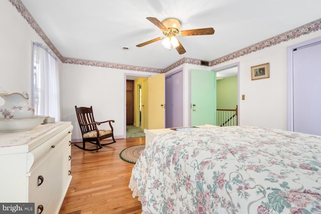 bedroom with light wood-type flooring, a ceiling fan, and visible vents