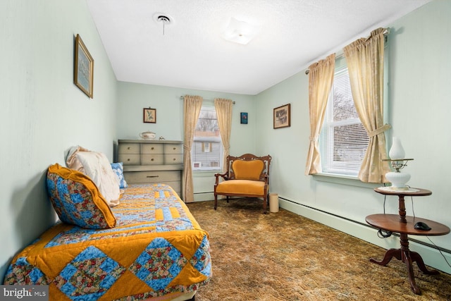 carpeted bedroom featuring a textured ceiling and a baseboard heating unit