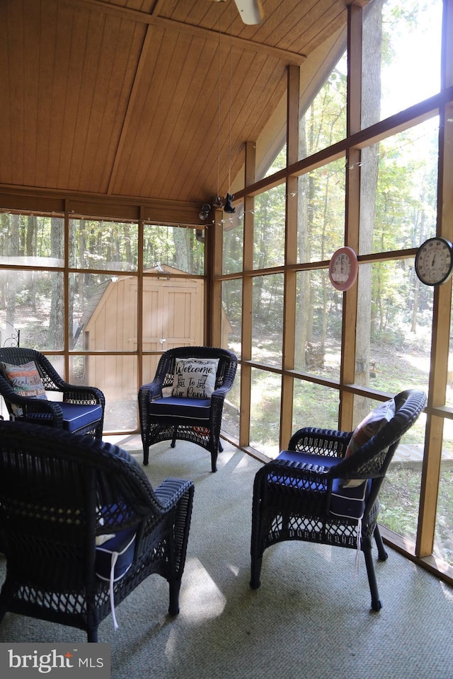 sunroom / solarium featuring a wealth of natural light, wooden ceiling, and vaulted ceiling