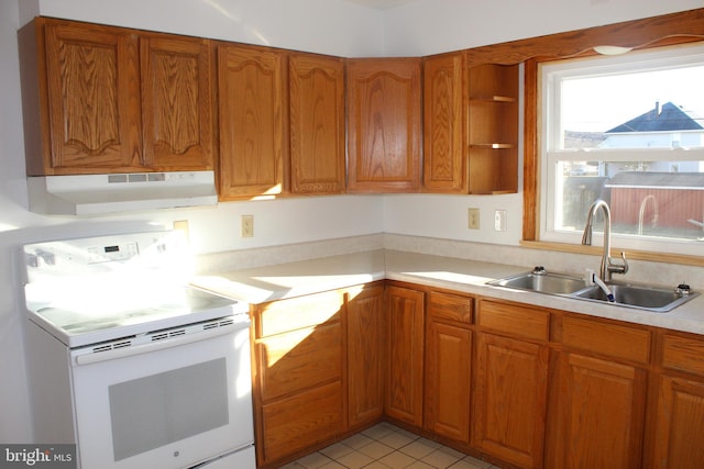 kitchen with under cabinet range hood, light countertops, brown cabinets, white electric range, and a sink