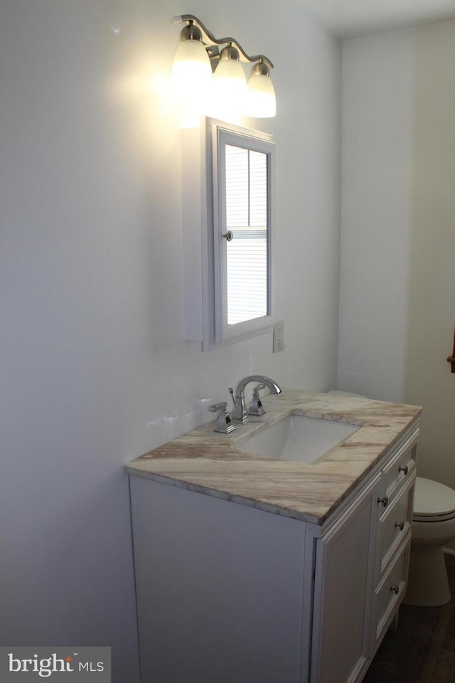 half bathroom with toilet and vanity