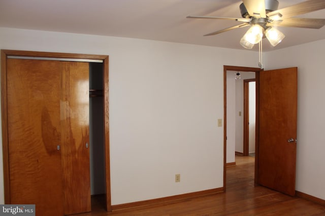 unfurnished bedroom with a closet, a ceiling fan, baseboards, and wood finished floors