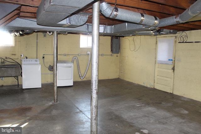 basement with a sink, electric panel, and washer and clothes dryer