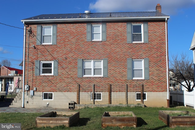 view of side of home with brick siding and a vegetable garden