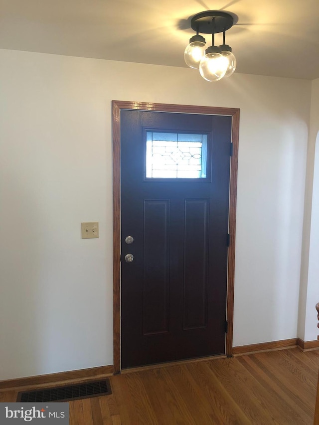 entrance foyer featuring visible vents, baseboards, and wood finished floors
