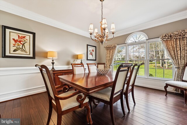 dining area featuring dark wood finished floors, baseboards, a notable chandelier, and crown molding