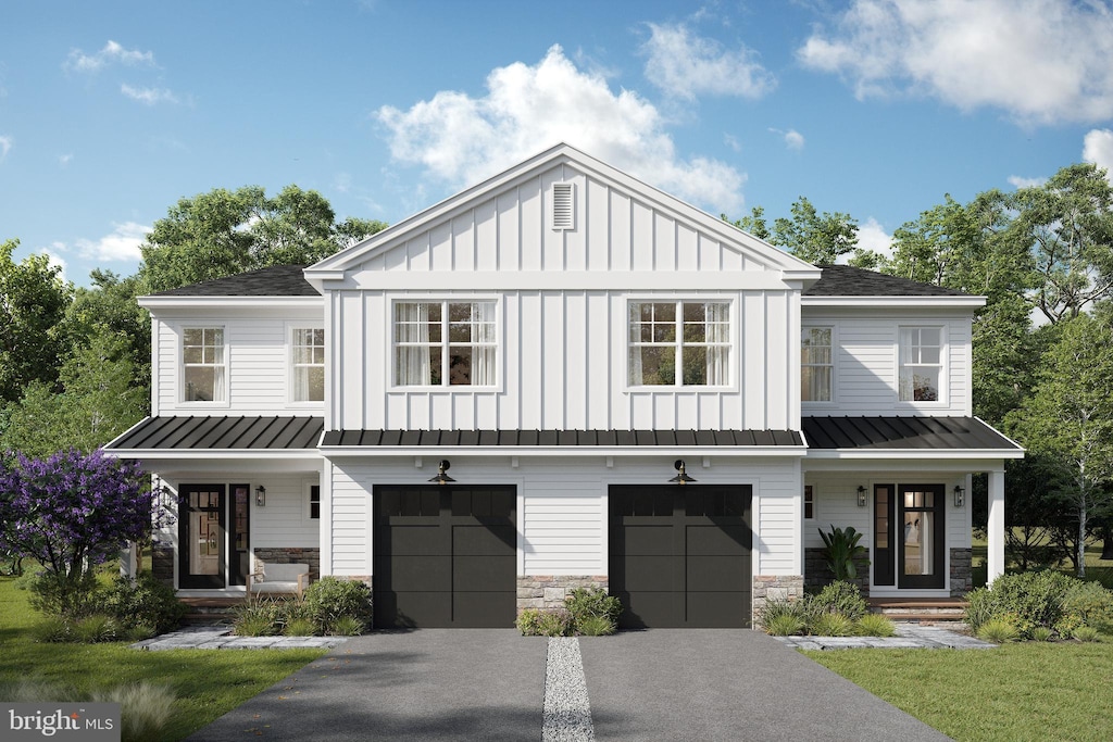 modern inspired farmhouse featuring a standing seam roof, asphalt driveway, board and batten siding, a garage, and covered porch