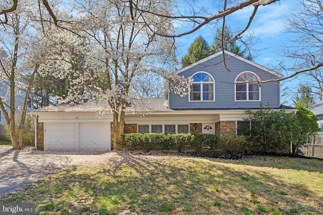 1220 Wendover Rd, Bryn Mawr, PA 19010 - traditional home with a front lawn, stone siding, an attached garage, and driveway