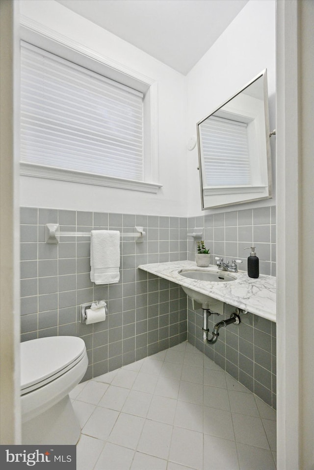 1220 Wendover Rd, Bryn Mawr, PA 19010 - half bathroom featuring toilet, tile walls, tile patterned flooring, and a sink
