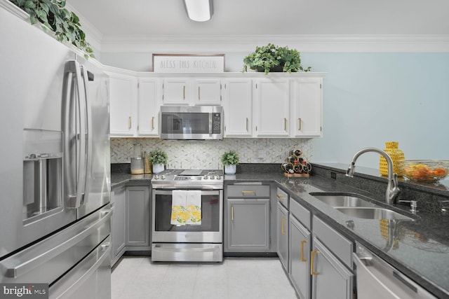 kitchen with a sink, appliances with stainless steel finishes, gray cabinets, and tasteful backsplash