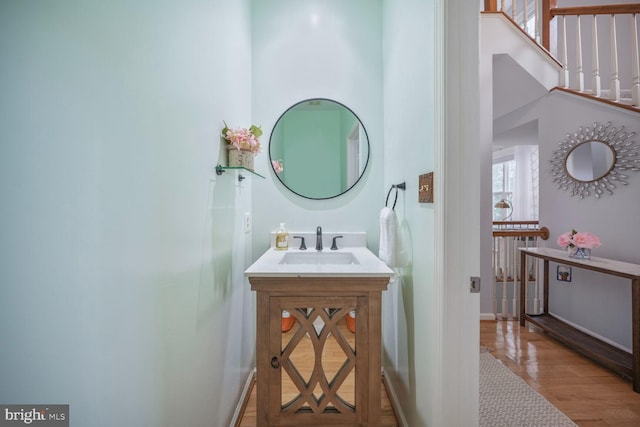 bathroom featuring vanity, baseboards, and wood finished floors
