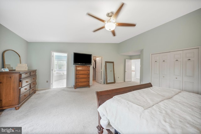bedroom featuring baseboards, vaulted ceiling, light carpet, and a closet