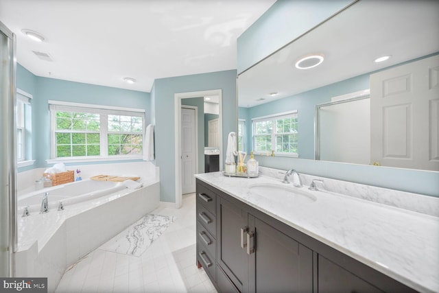 bathroom featuring baseboards, visible vents, a garden tub, and vanity