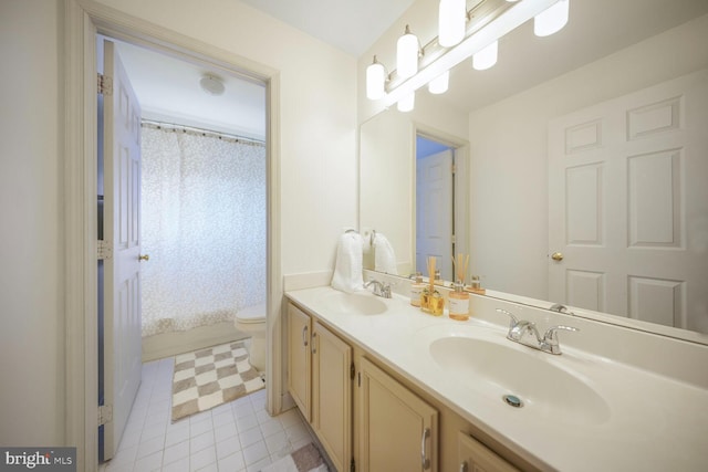 full bathroom with double vanity, toilet, and a sink