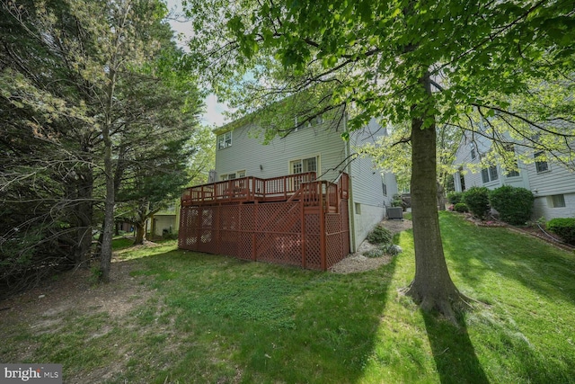 back of property featuring a lawn and a deck