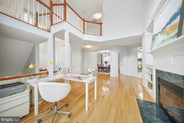 interior space with a towering ceiling, wood finished floors, and a premium fireplace