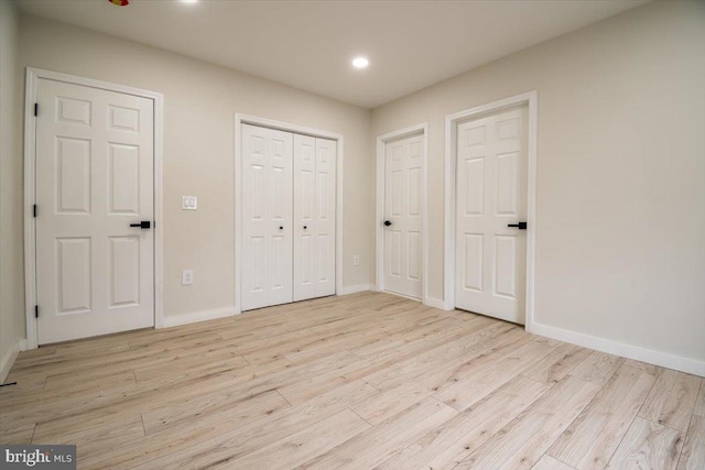 unfurnished bedroom featuring recessed lighting, baseboards, light wood-style flooring, and a closet