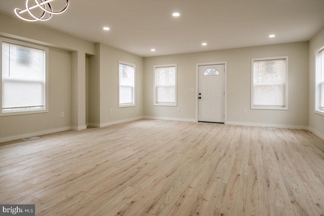 interior space featuring light wood-style floors, recessed lighting, baseboards, and visible vents