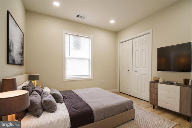 bedroom with a closet, visible vents, baseboards, recessed lighting, and light wood-style flooring