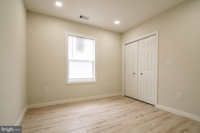 unfurnished bedroom with light wood-style flooring, recessed lighting, baseboards, visible vents, and a closet
