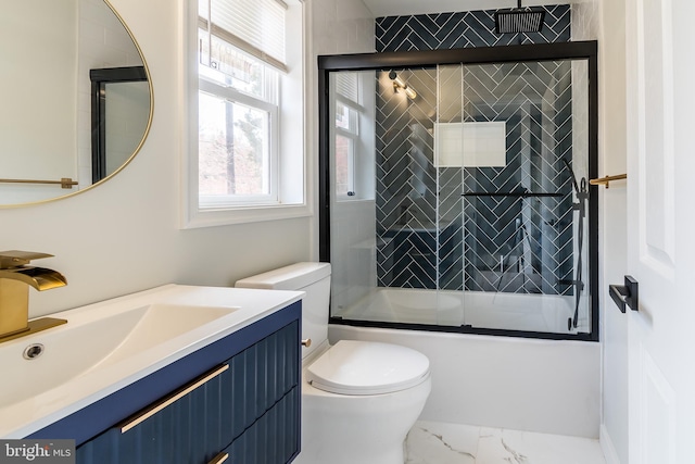 bathroom featuring toilet, enclosed tub / shower combo, marble finish floor, and vanity
