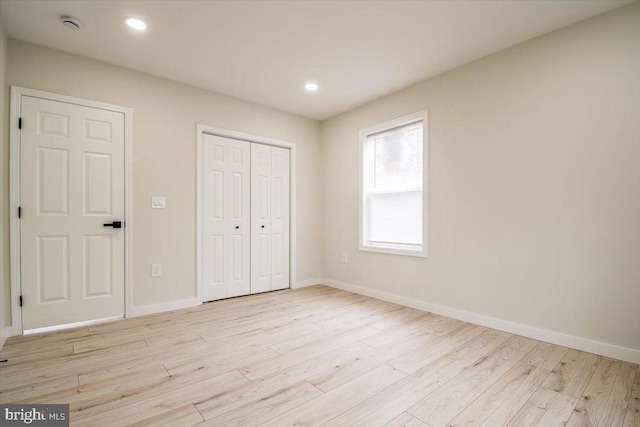 unfurnished bedroom featuring recessed lighting, baseboards, wood finished floors, and a closet