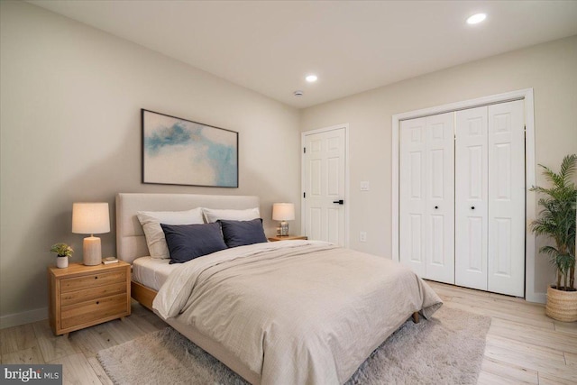 bedroom featuring light wood-style floors, recessed lighting, baseboards, and a closet