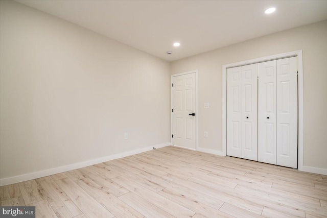 unfurnished bedroom with recessed lighting, baseboards, a closet, and light wood-style floors