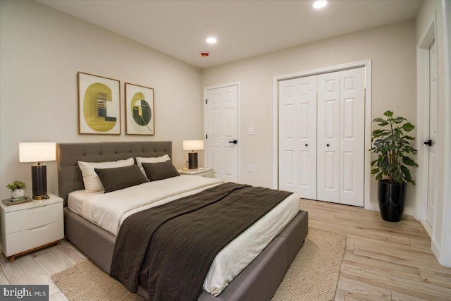 bedroom featuring light wood-type flooring, a closet, and recessed lighting