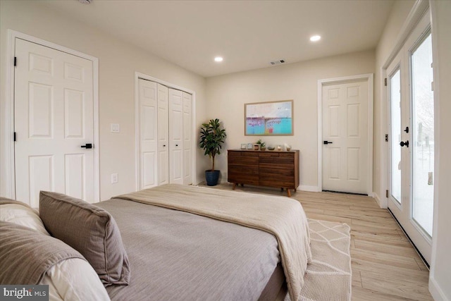 bedroom with multiple windows, light wood finished floors, recessed lighting, and visible vents