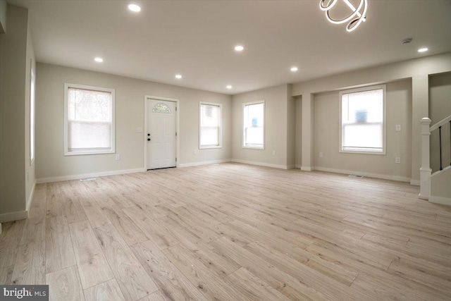 unfurnished living room with stairway, recessed lighting, baseboards, and light wood finished floors