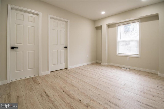 unfurnished bedroom featuring light wood-style floors, recessed lighting, baseboards, and visible vents
