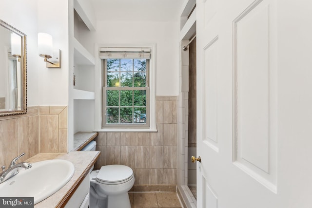 full bathroom featuring tile patterned flooring, vanity, wainscoting, toilet, and tile walls