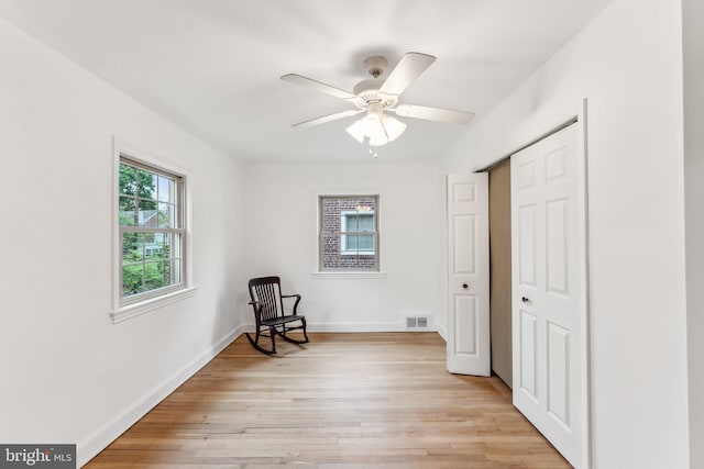 unfurnished room with baseboards, a ceiling fan, light wood-style flooring, and visible vents