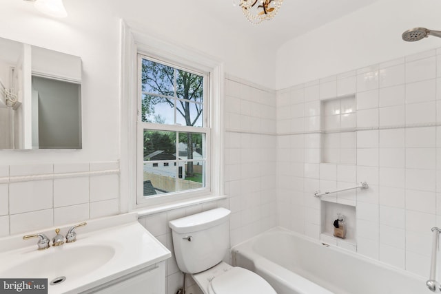 full bath featuring toilet, tile walls, shower / washtub combination, and vanity