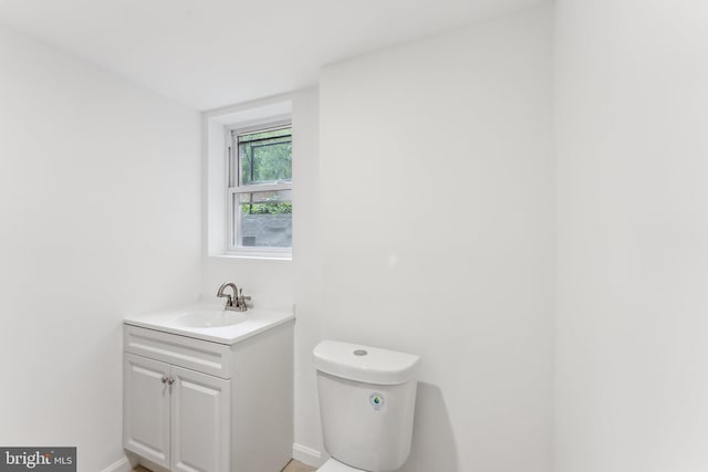 bathroom with vanity, baseboards, and toilet