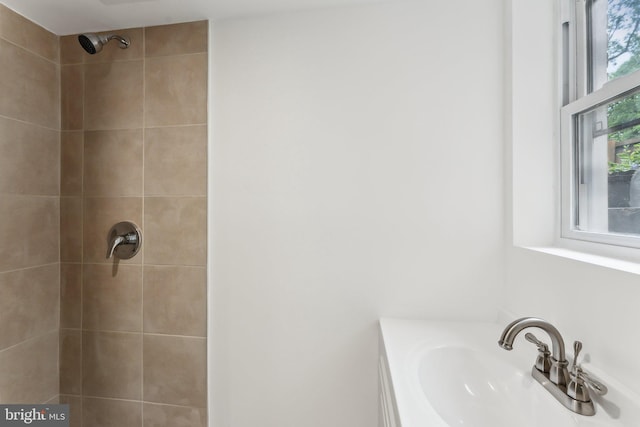 bathroom with a sink and tiled shower